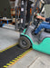 Insitu product image of non-slip, black and yellow Smartgrip Industrial matting Roll used in warehouse being driven over by forklift