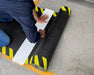 Insitu product image of non-slip, black and yellow Smartgrip Industrial matting Roll being cut with cutting board and safety knife